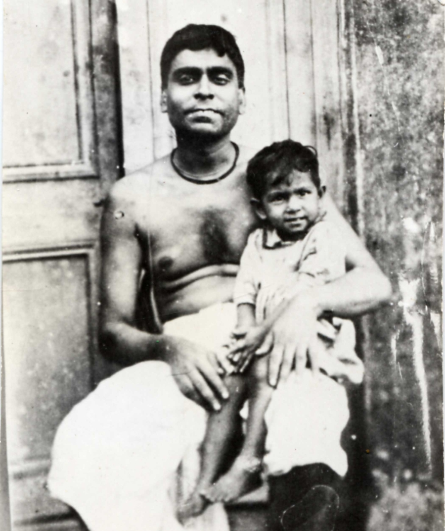 A young Srila Bhaktisiddhanta Saraswati Thakur is seated on his father's lap, Srila Bhaktivinoda Thakur.